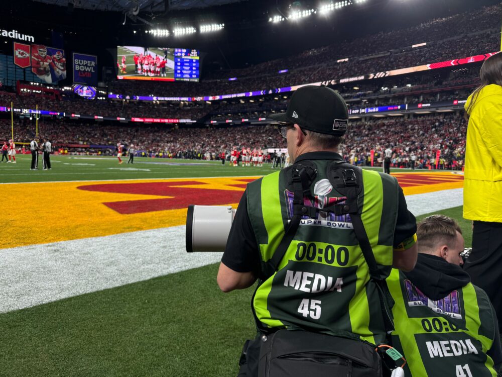 A NFL photographer capturing live content on the field.
